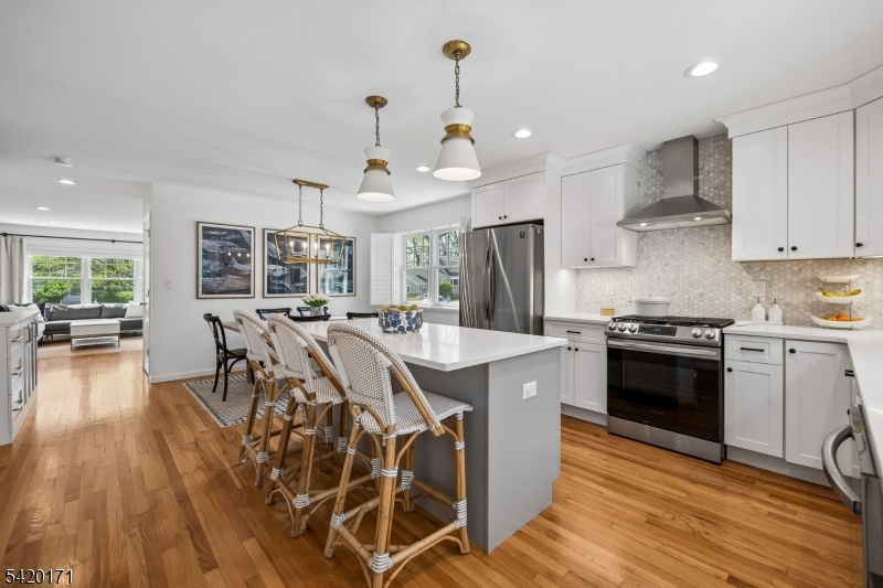 41 Milton Avenue Summit, NJ 07901 - Photo 7 of 39 a kitchen with stainless steel appliances kitchen island granite countertop a stove a sink a refrigerator and a dining table with wooden floor