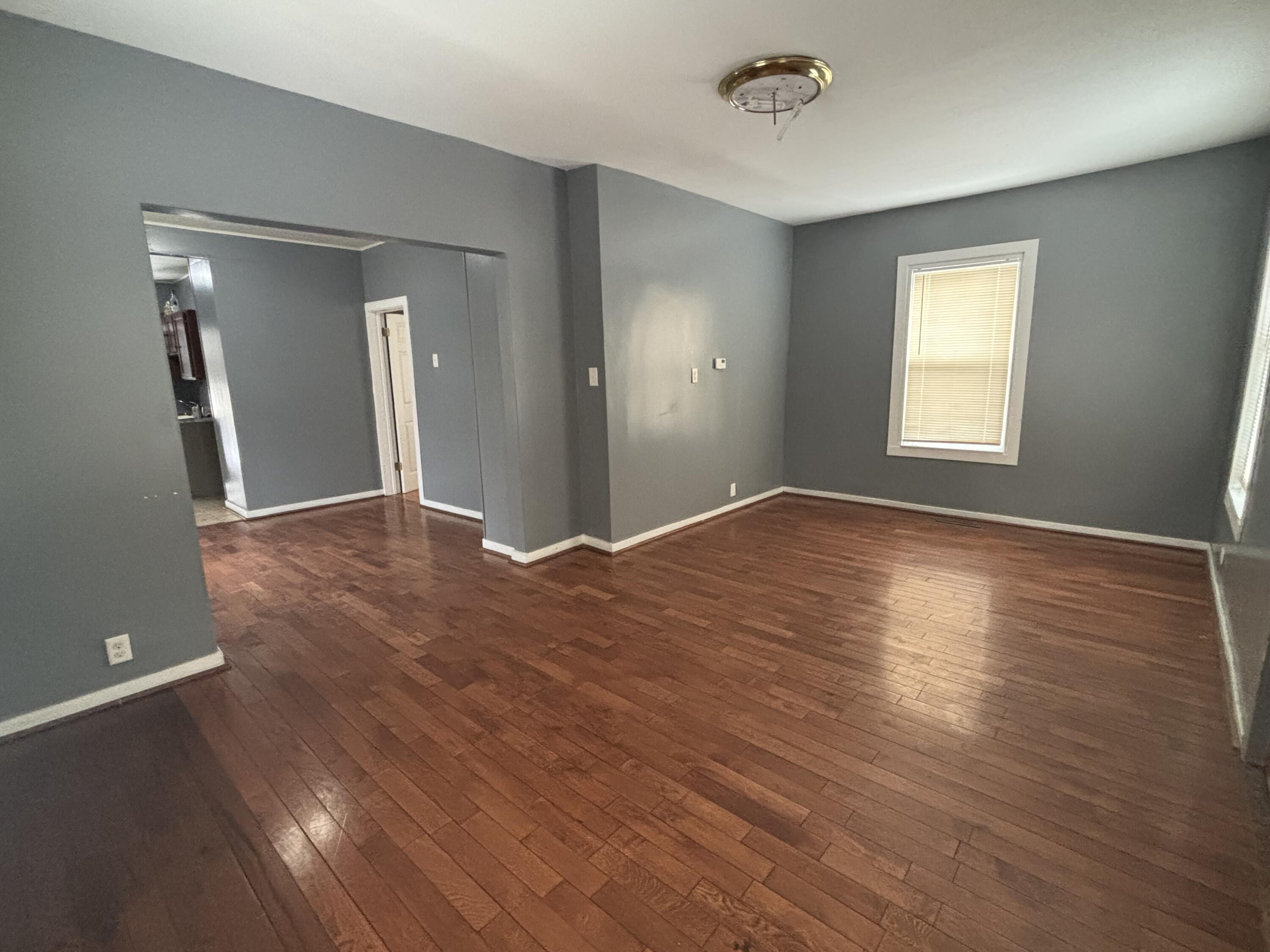 3953 Monroe Street Gary, IN 46408 - Photo 2 of 13 an empty room with wooden floor and windows