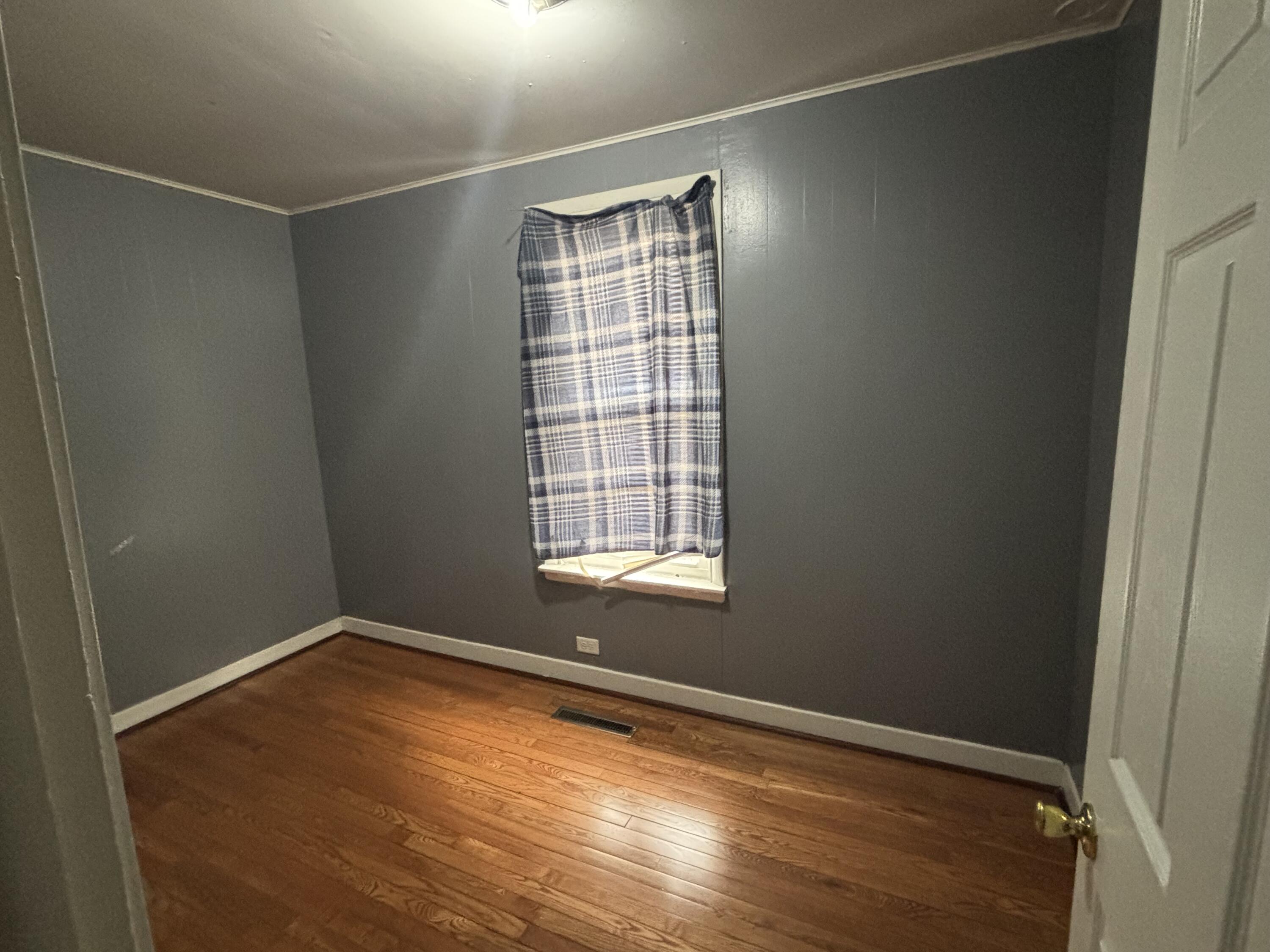 3953 Monroe Street Gary, IN 46408 - Photo 7 of 13 a view of an empty room with wooden floor and a window