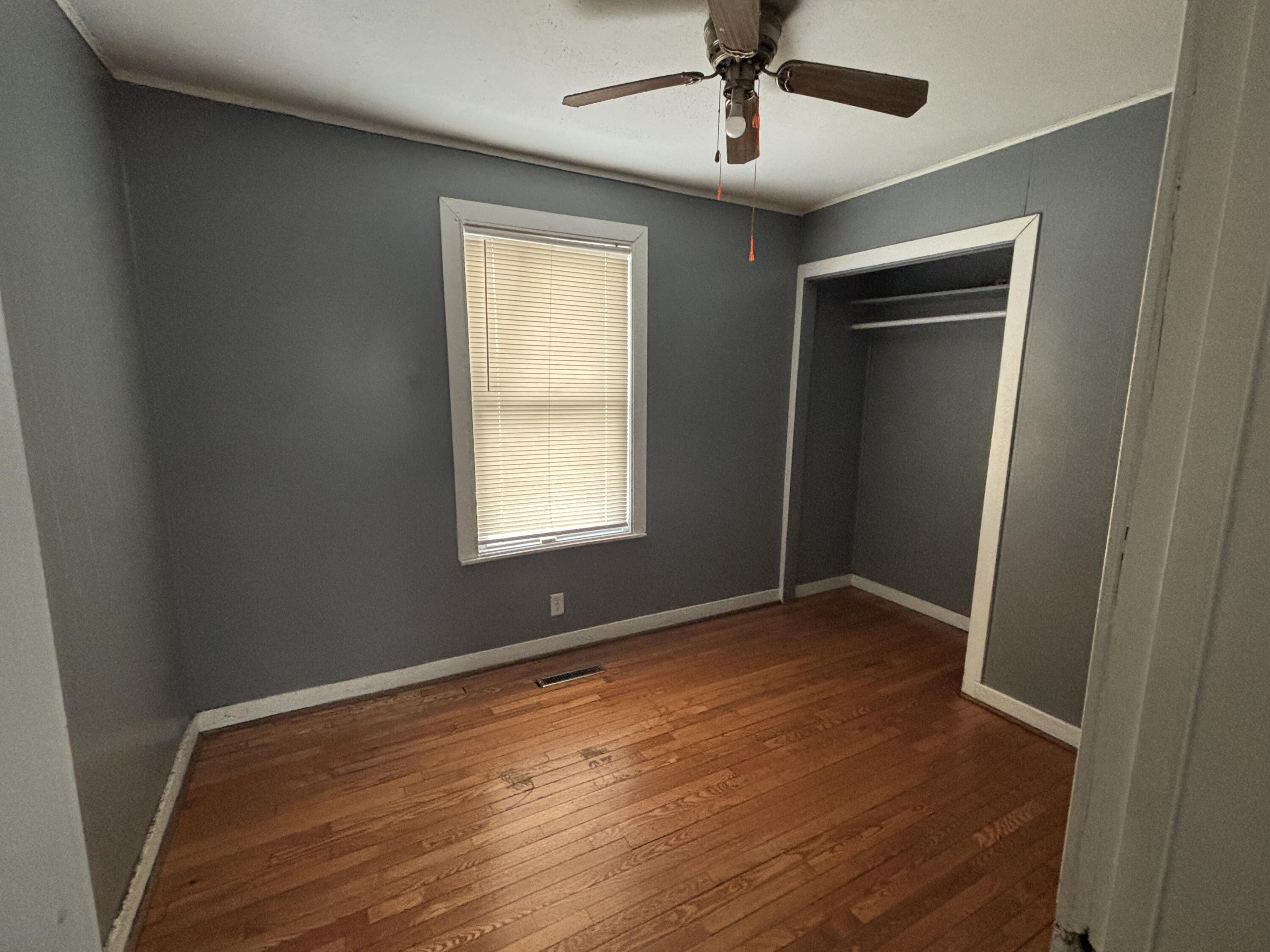 3953 Monroe Street Gary, IN 46408 - Photo 8 of 13 an empty room with wooden floor ceiling fan and windows