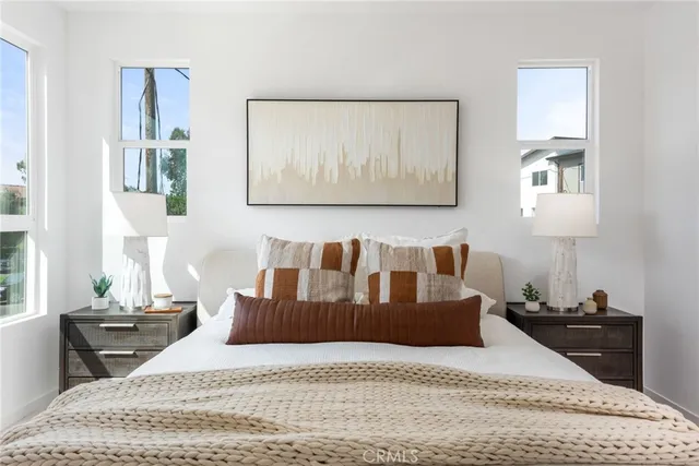 a large bedroom with a bed and wooden floor