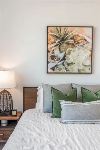 a bedroom with a bed and painting on the wall