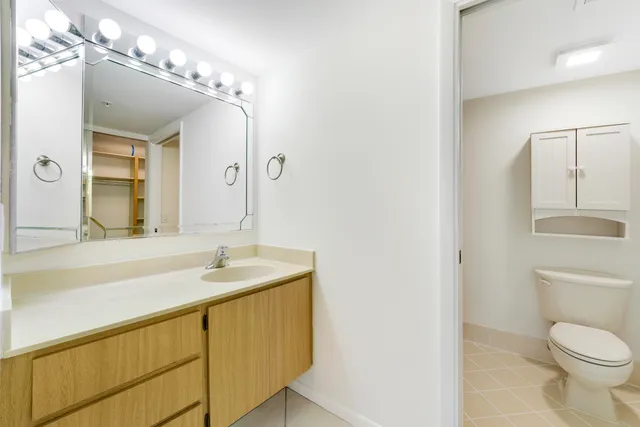 a bathroom with a sink a toilet and a mirror