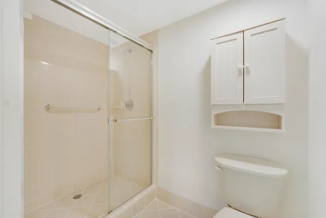 a bathroom with a shower a toilet and a sink