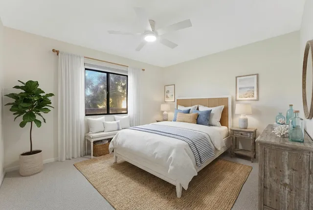 a bedroom with a large bed and a potted plant
