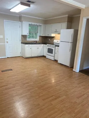 a kitchen with granite countertop a stove a refrigerator and a sink