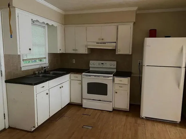 a kitchen with white cabinets and white appliances
