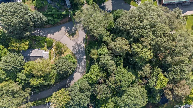 an aerial view of residential house with outdoor space and trees all around