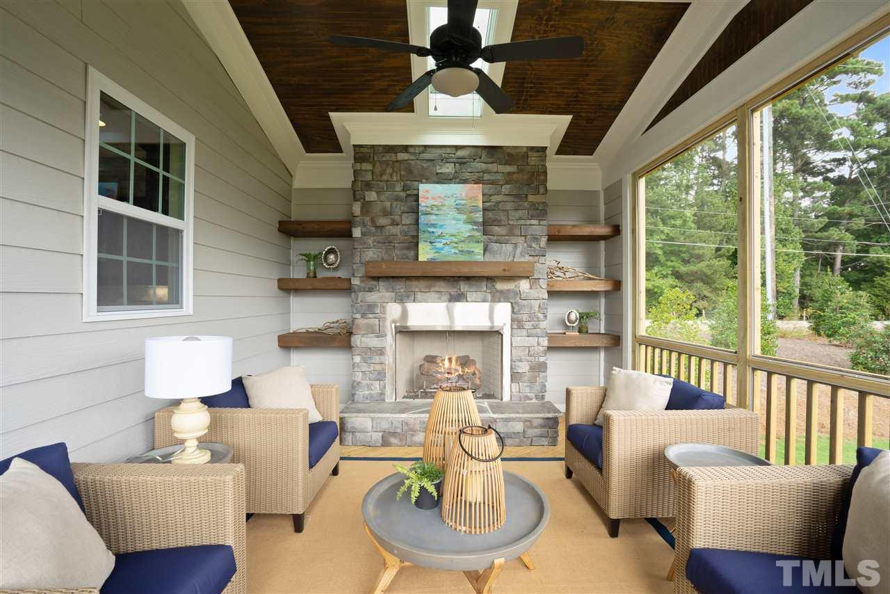 1040 Manchaca Loop Apex, NC 27539 - Photo 30 of 30 large screeend porch with stone fireplace with built in cabinets and shelving