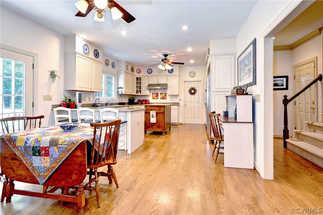 105 Mid Ocean Williamsburg, VA 23188 - Photo 7 of 36 a kitchen with stainless steel appliances granite countertop a refrigerator a stove top oven a dining table and chairs with wooden floor