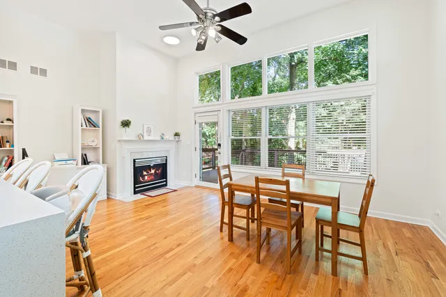 a dining room with furniture a fireplace and wooden floor