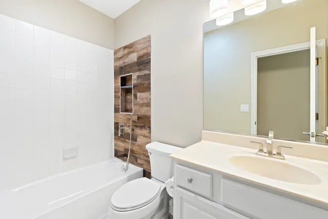 a living room with furniture a flat screen tv and kitchen view