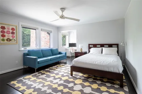a spacious bedroom with a bed a couch and a window