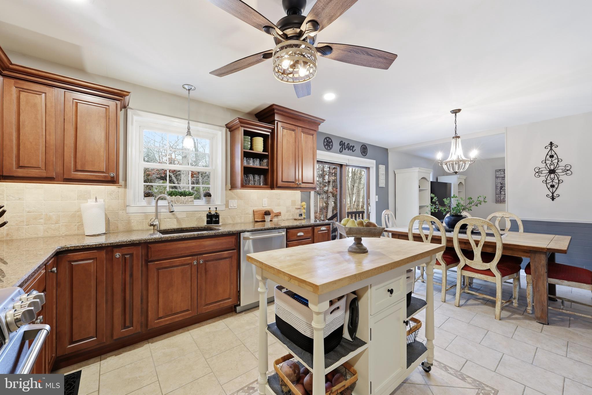 4 Prosit Lane Ocean View, NJ 08230 - Photo 14 of 29 a open kitchen with stainless steel appliances granite countertop a stove a refrigerator a sink a dining table and chairs with wooden floor