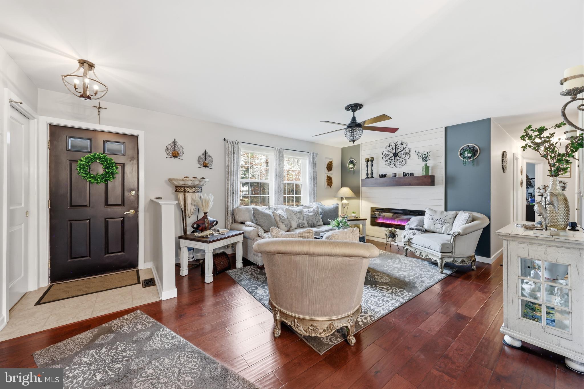 4 Prosit Lane Ocean View, NJ 08230 - Photo 8 of 29 a living room with furniture a fireplace and a chandelier