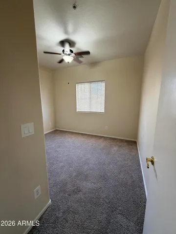 an empty room with a ceiling fan and a window