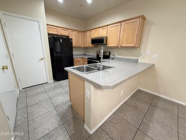 a kitchen with a sink a refrigerator a stove a microwave and cabinets