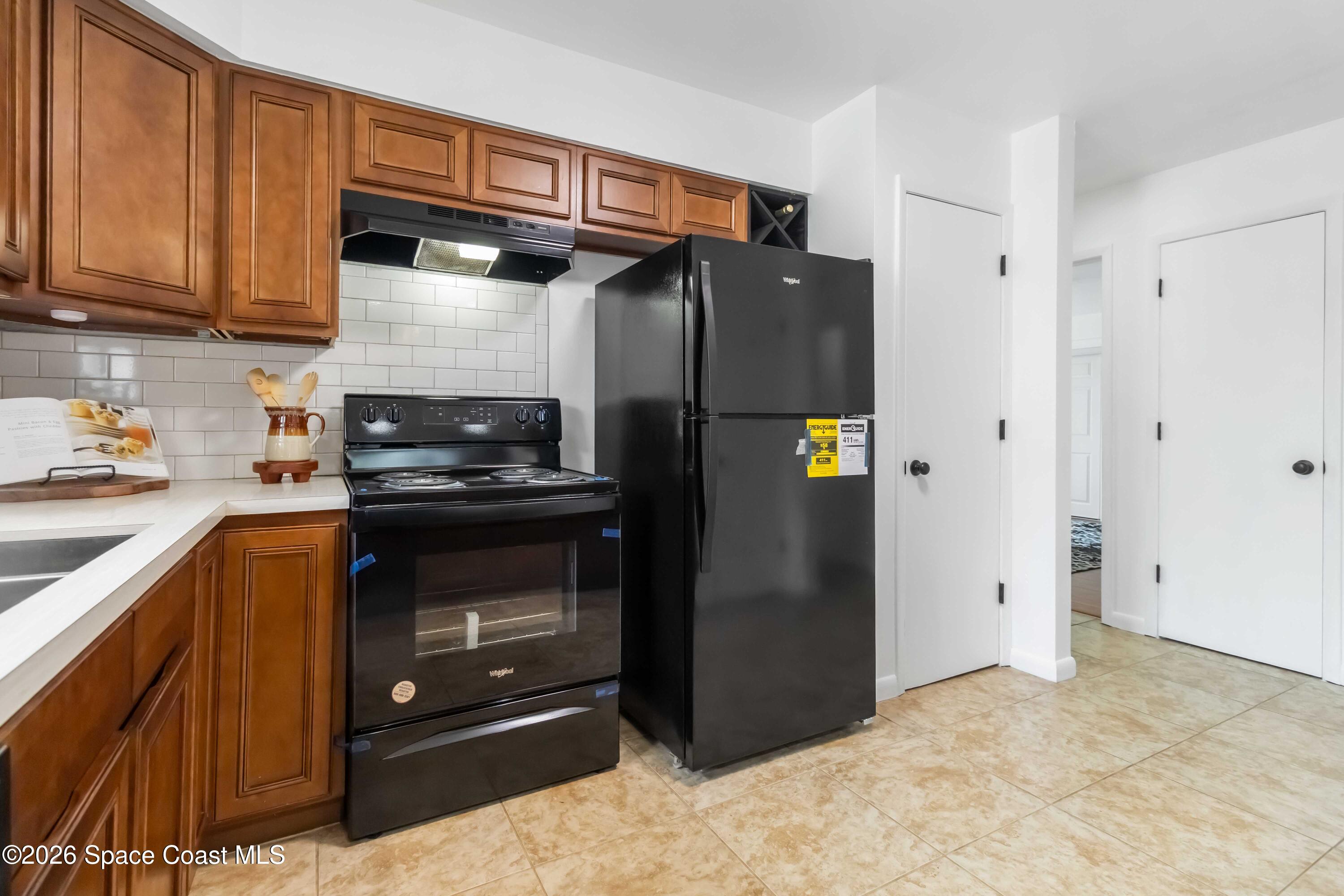 21 Branch Street Melbourne, FL 32901 - Photo 12 of 30 a kitchen with stainless steel appliances granite countertop a refrigerator and a stove