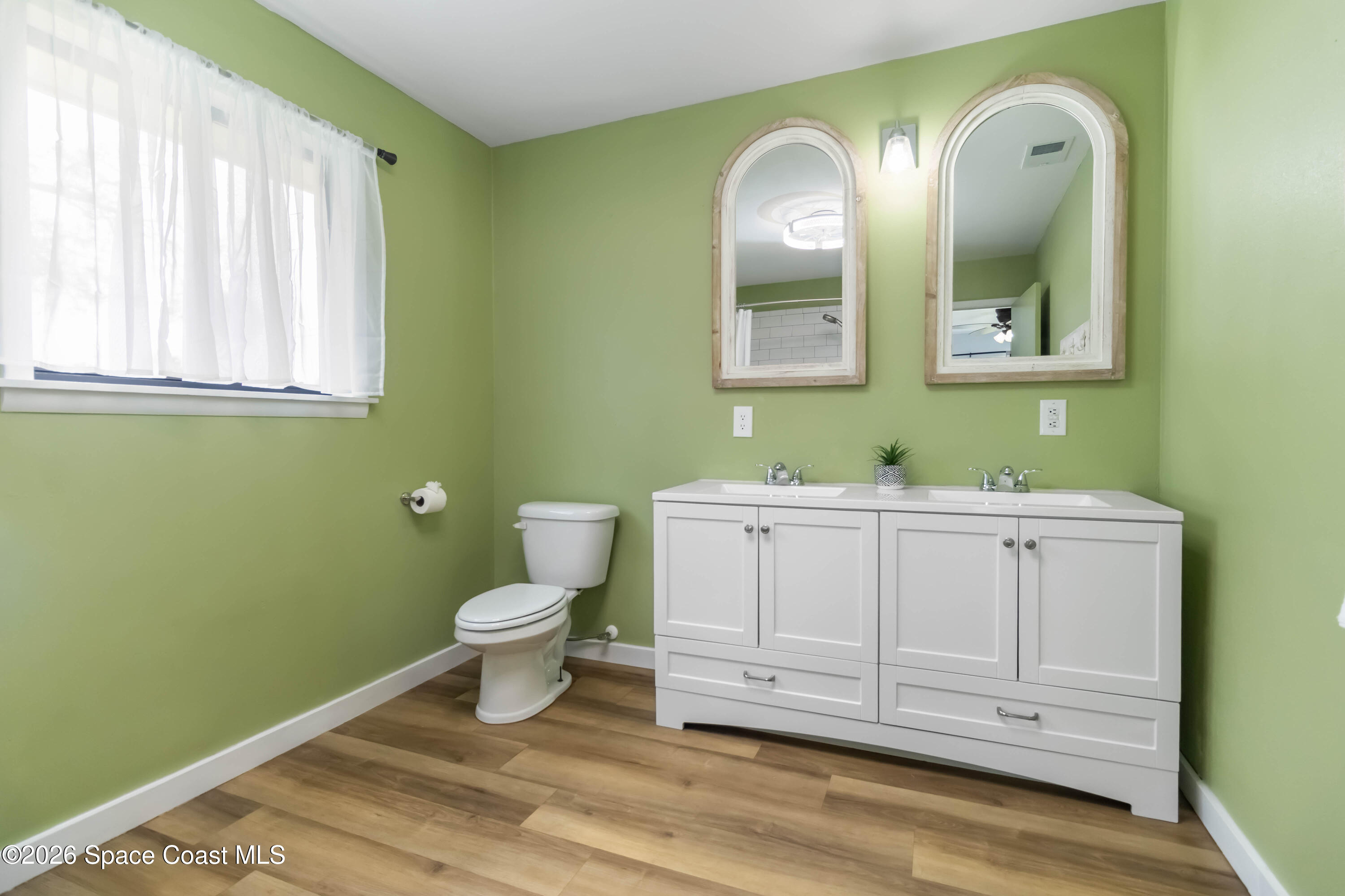21 Branch Street Melbourne, FL 32901 - Photo 23 of 30 a bathroom with a toilet sink and mirror