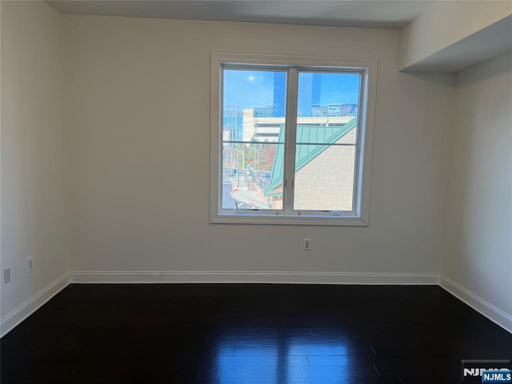 2001 Hudson Terrace, Unit 501 Fort Lee, NJ 07024 - Photo 13 of 23 an empty room with wooden floor and windows