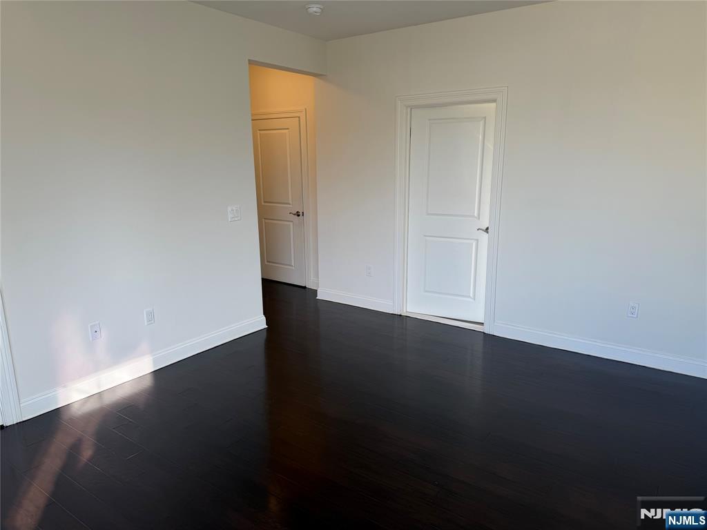 2001 Hudson Terrace, Unit 501 Fort Lee, NJ 07024 - Photo 7 of 23 an empty room with wooden floor and windows