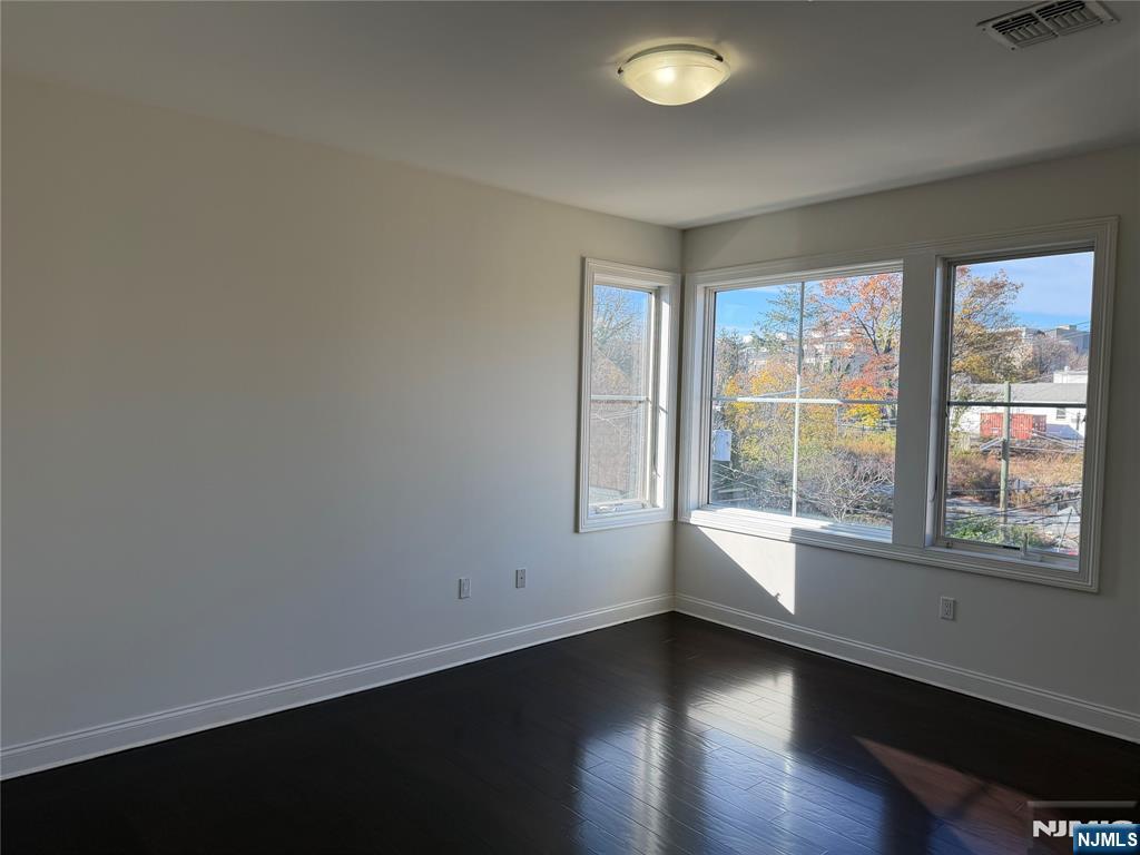 2001 Hudson Terrace, Unit 501 Fort Lee, NJ 07024 - Photo 9 of 23 an empty room with wooden floor and windows