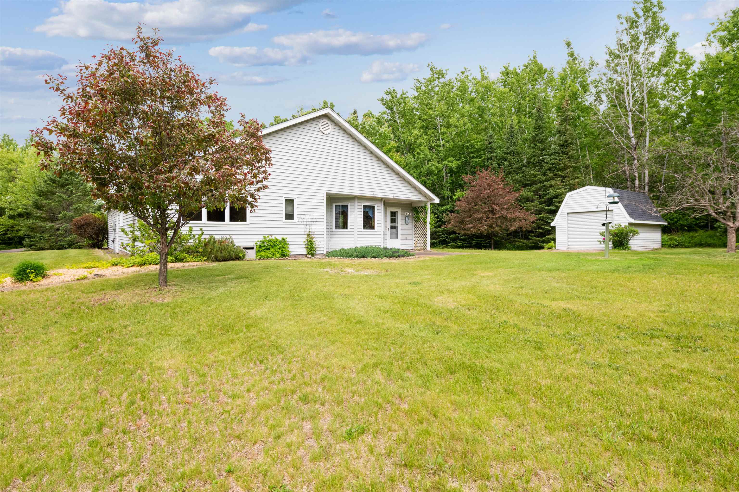5948 Lavaque Road Duluth, MN 55803 - Photo 17 of 22 Rear view of property with a garage, a lawn, and a storage unit
