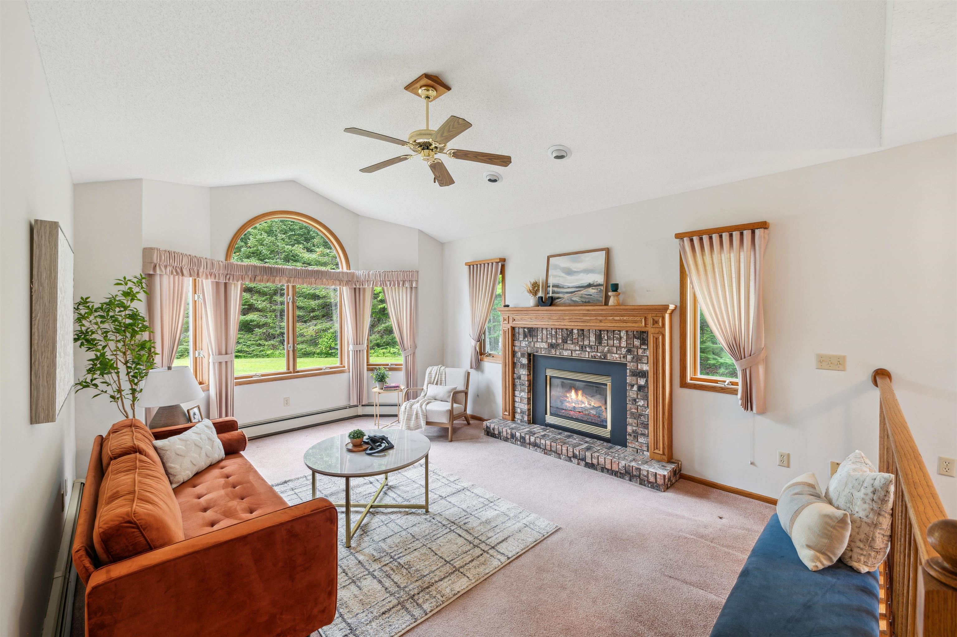 5948 Lavaque Road Duluth, MN 55803 - Photo 3 of 22 Living area featuring carpet, ceiling fan, a baseboard heating unit, lofted ceiling, and a fireplace