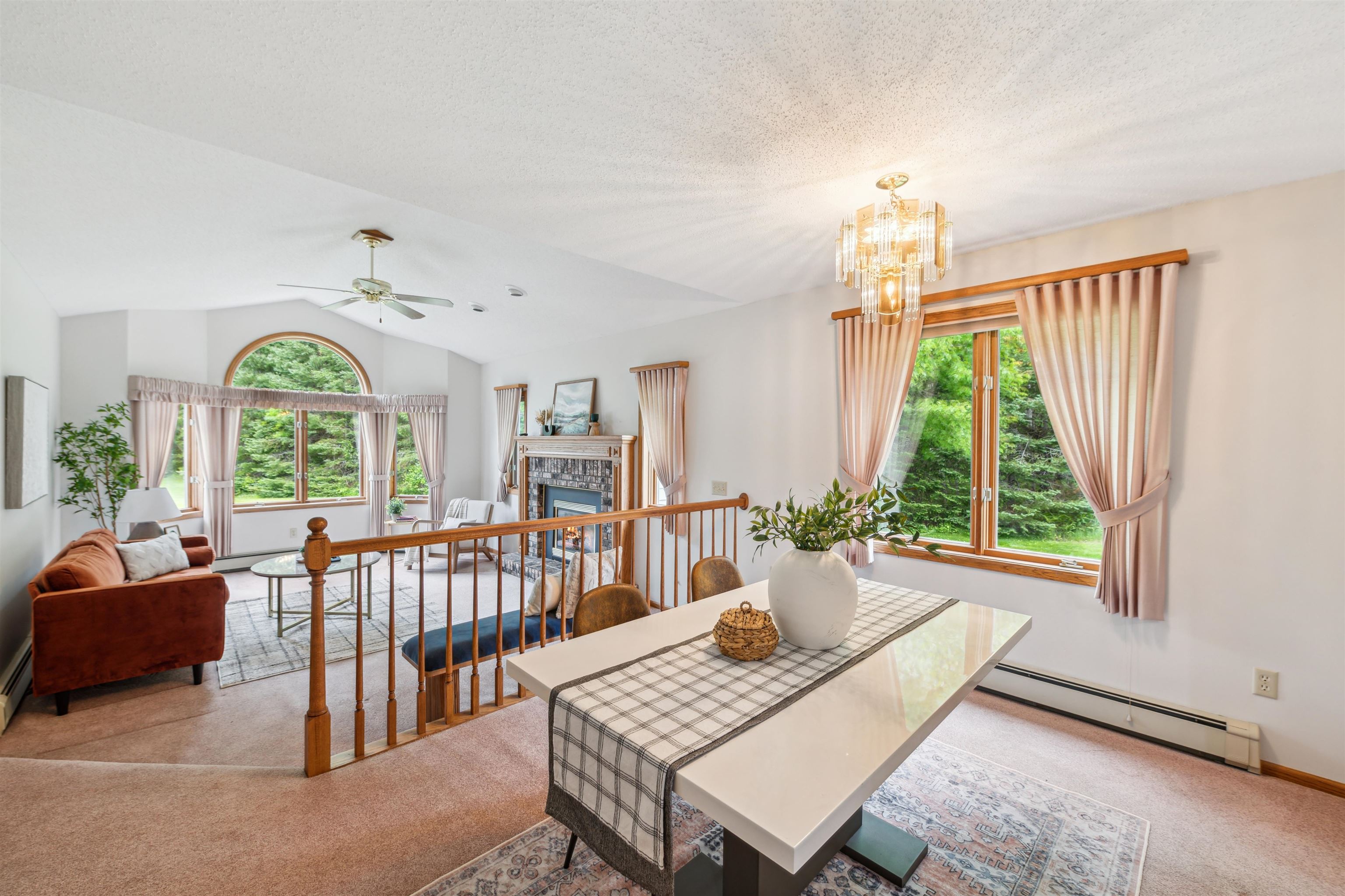 5948 Lavaque Road Duluth, MN 55803 - Photo 5 of 22 Dining area with baseboard heating, carpet, a fireplace, a chandelier, and a ceiling fan