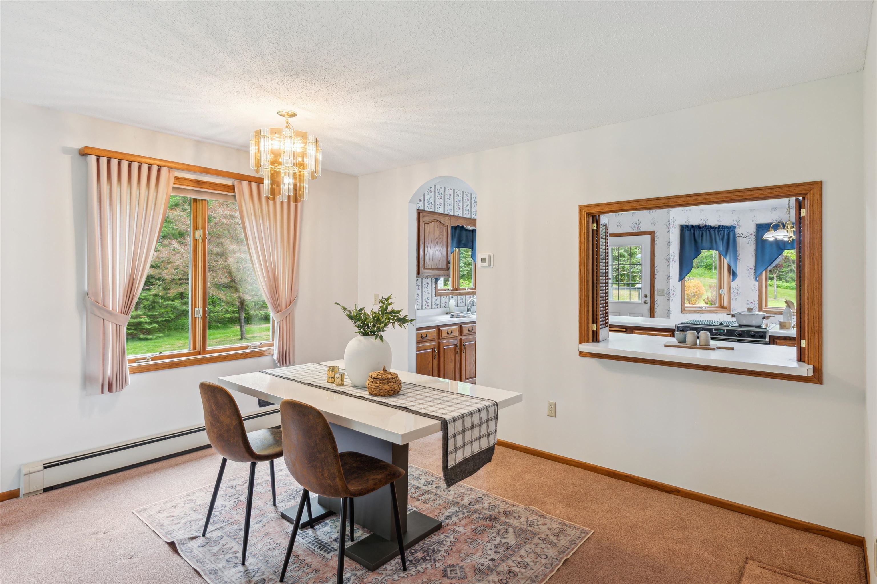 5948 Lavaque Road Duluth, MN 55803 - Photo 6 of 22 Dining space with baseboard heating, light colored carpet, a chandelier, arched walkways, and a textured ceiling