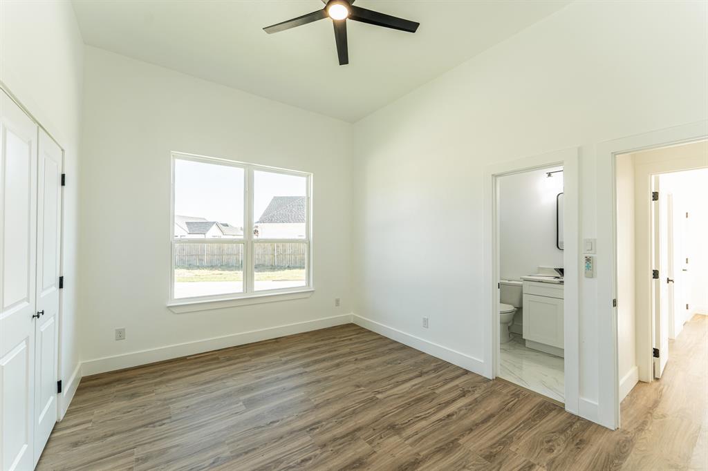 2147 Heath Street Sulphur Springs, TX 75482 - Photo 21 of 40 an empty room with wooden floor cabinet and windows