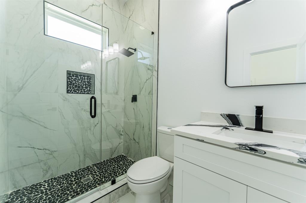 2147 Heath Street Sulphur Springs, TX 75482 - Photo 23 of 40 a bathroom with a granite countertop sink a toilet and shower