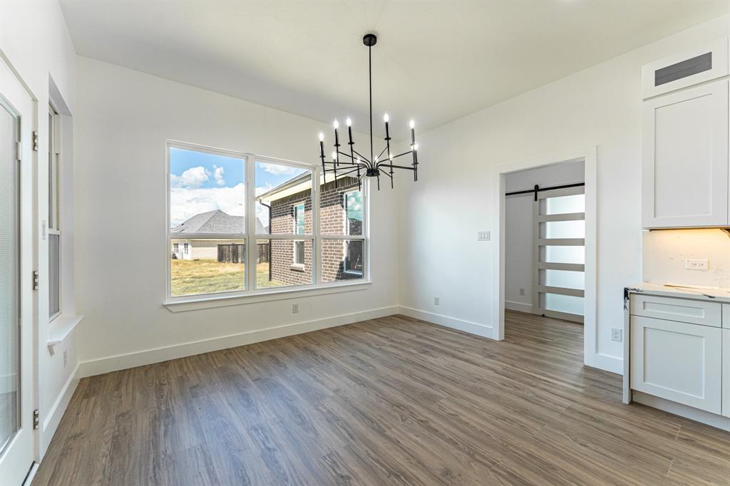 2147 Heath Street Sulphur Springs, TX 75482 - Photo 7 of 40 a view of a room with wooden floor a ceiling fan and windows