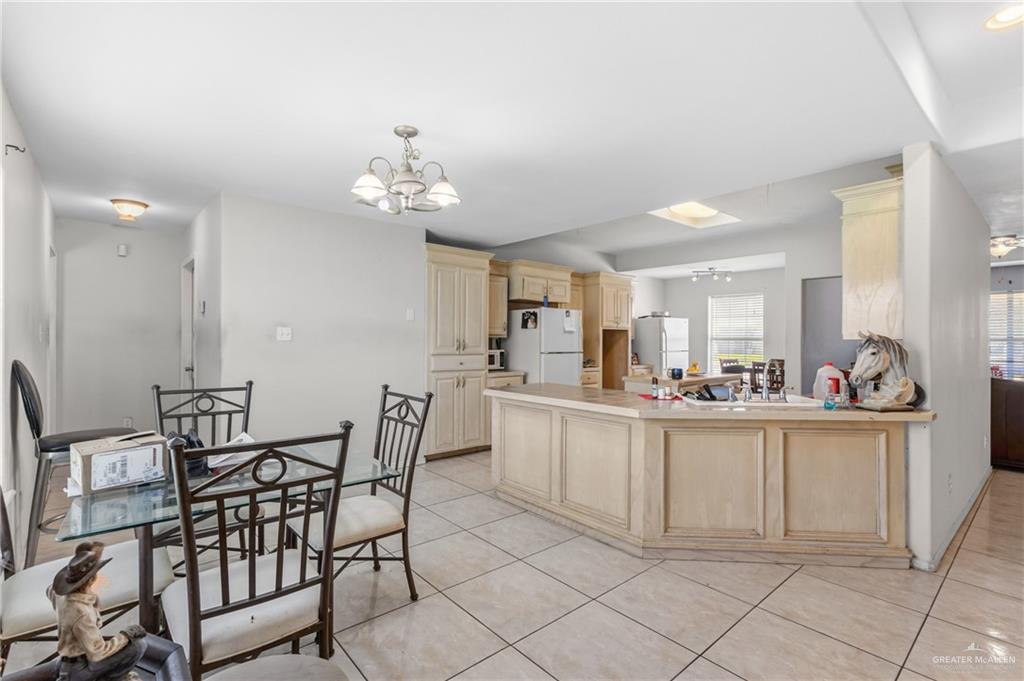 402 Mockingbird Lane Edcouch, TX 78538 - Photo 3 of 25 Expansive kitchen area featuring light-toned cabinetry, a spacious island with paneling, and tile flooring