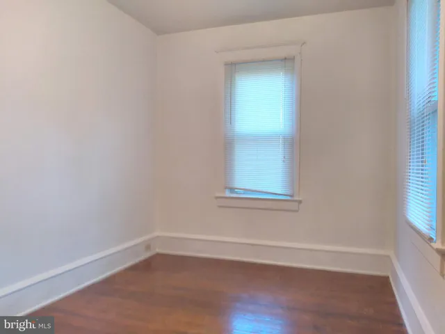 a view of an empty room with wooden closet and a window