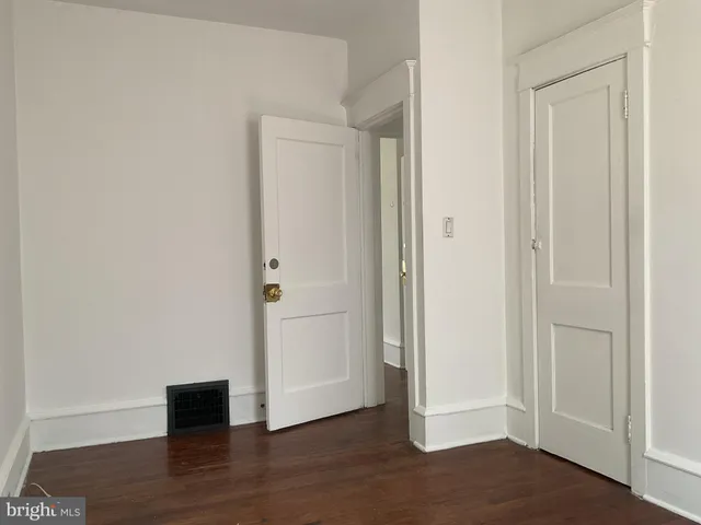 an empty room with wooden floor and closet