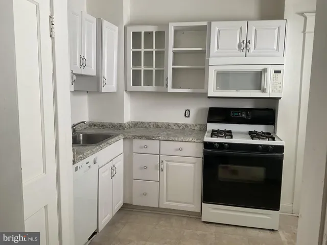 a kitchen with granite countertop white cabinets and stainless steel appliances