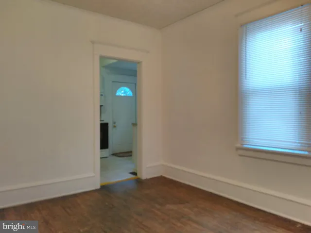 a view of an empty room with closet and mirror