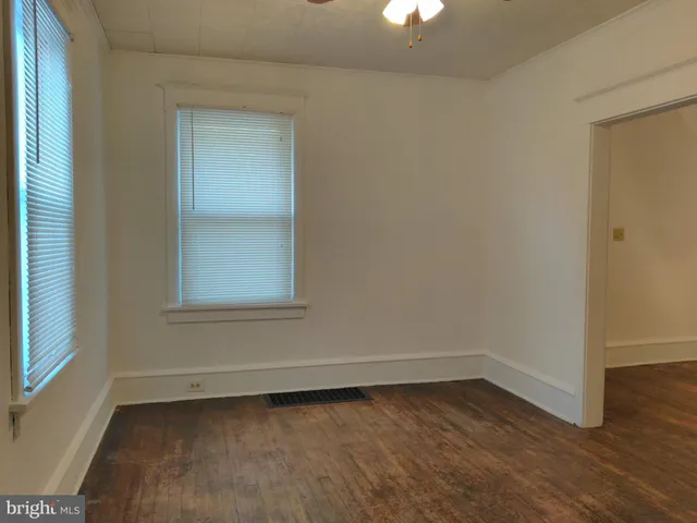 a view of a small space with wooden floor and a window