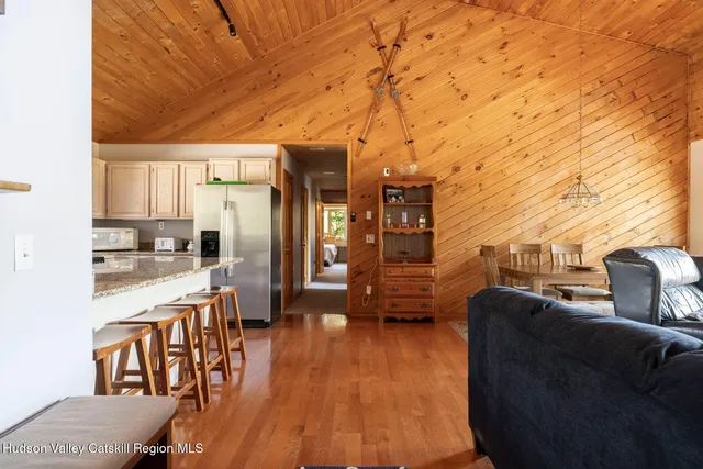 a living room with stainless steel appliances kitchen island granite countertop furniture and a wooden floor