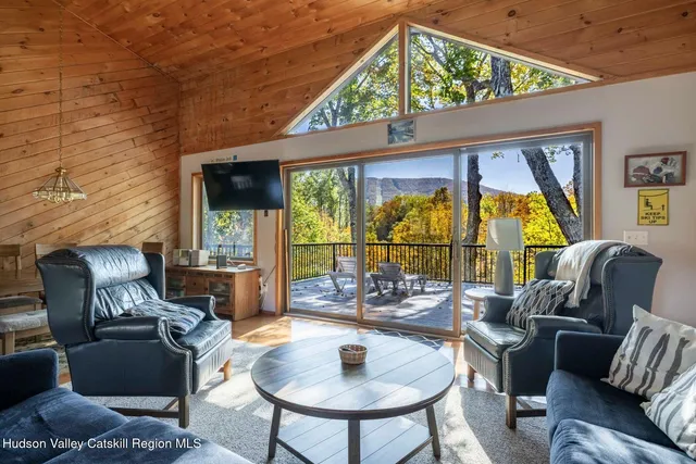 a dining room with furniture a flat screen tv and a floor to ceiling window