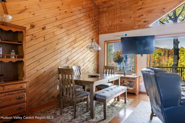 a view of a patio with table and chairs a barbeque with wooden floor and fence