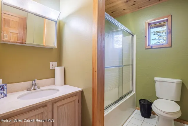 a bathroom with a granite countertop toilet sink and mirror