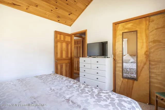 a view of bedroom with wooden floor and flat screen tv