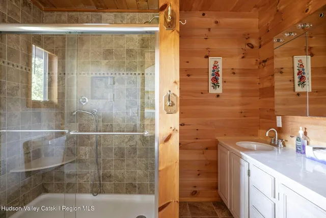 a bathroom with a shower sink and mirror