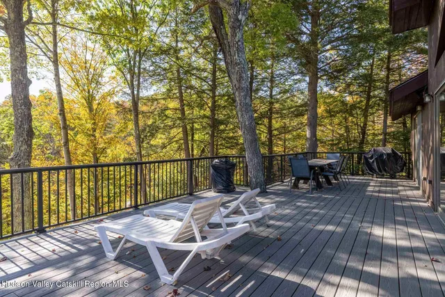 a view of a patio with table and chairs with wooden floor and fence