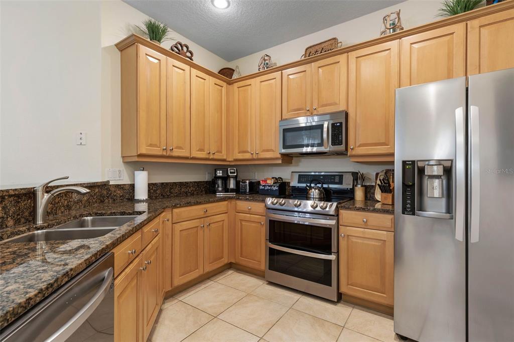 35 Ocean Crest Way, Unit 1124 Palm Coast, FL 32137 - Photo 11 of 81 a kitchen with stainless steel appliances granite countertop a refrigerator stove and sink