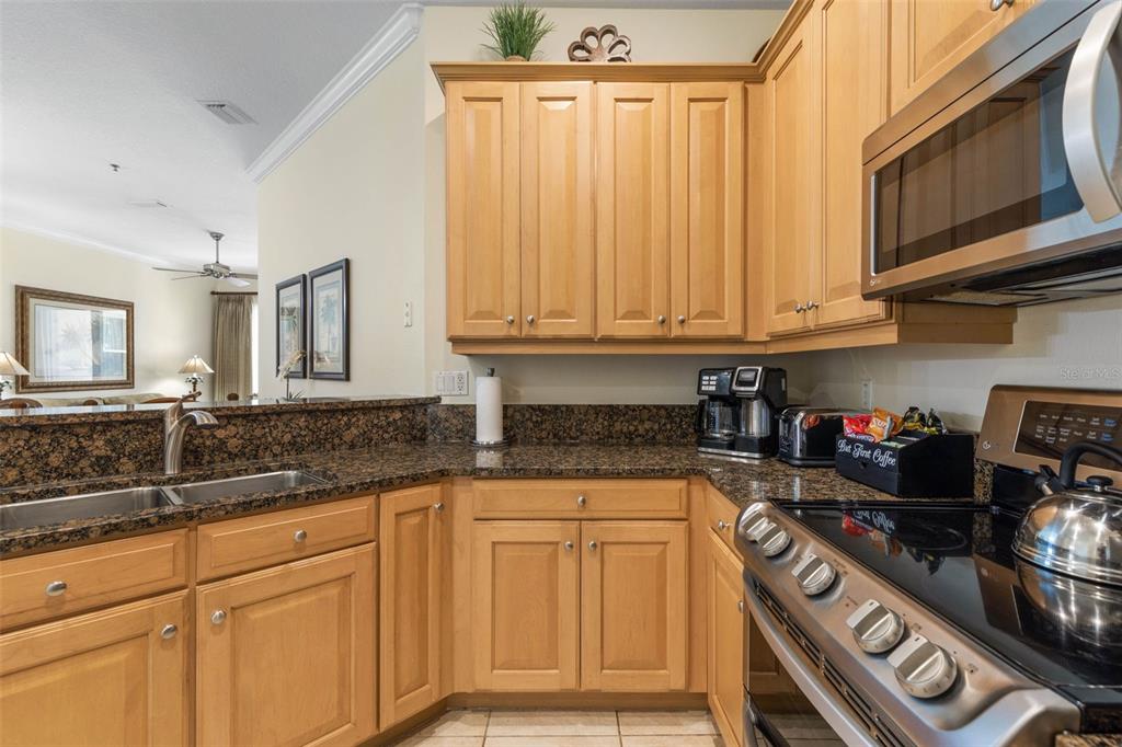 35 Ocean Crest Way, Unit 1124 Palm Coast, FL 32137 - Photo 12 of 81 a kitchen with granite countertop a stove sink and cabinets