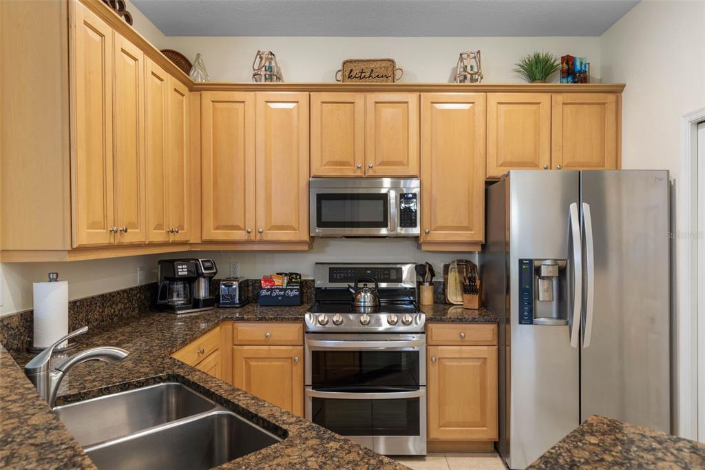 35 Ocean Crest Way, Unit 1124 Palm Coast, FL 32137 - Photo 14 of 81 a kitchen with stainless steel appliances granite countertop a refrigerator a stove and a sink