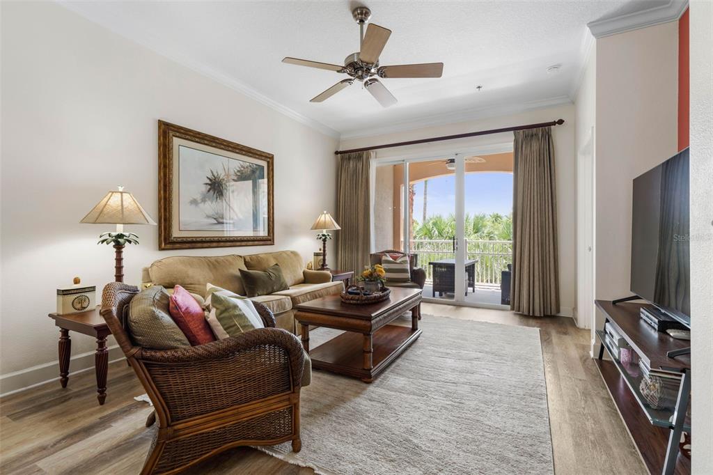 35 Ocean Crest Way, Unit 1124 Palm Coast, FL 32137 - Photo 4 of 81 a living room with furniture a large window and a flat screen tv